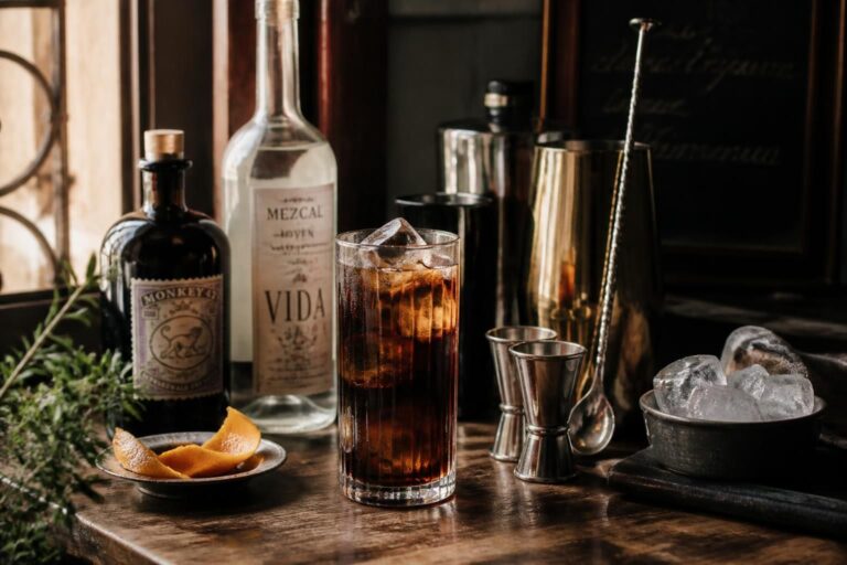 Cocktail sombre avec bouteilles, shaker et glaçons sur un comptoir