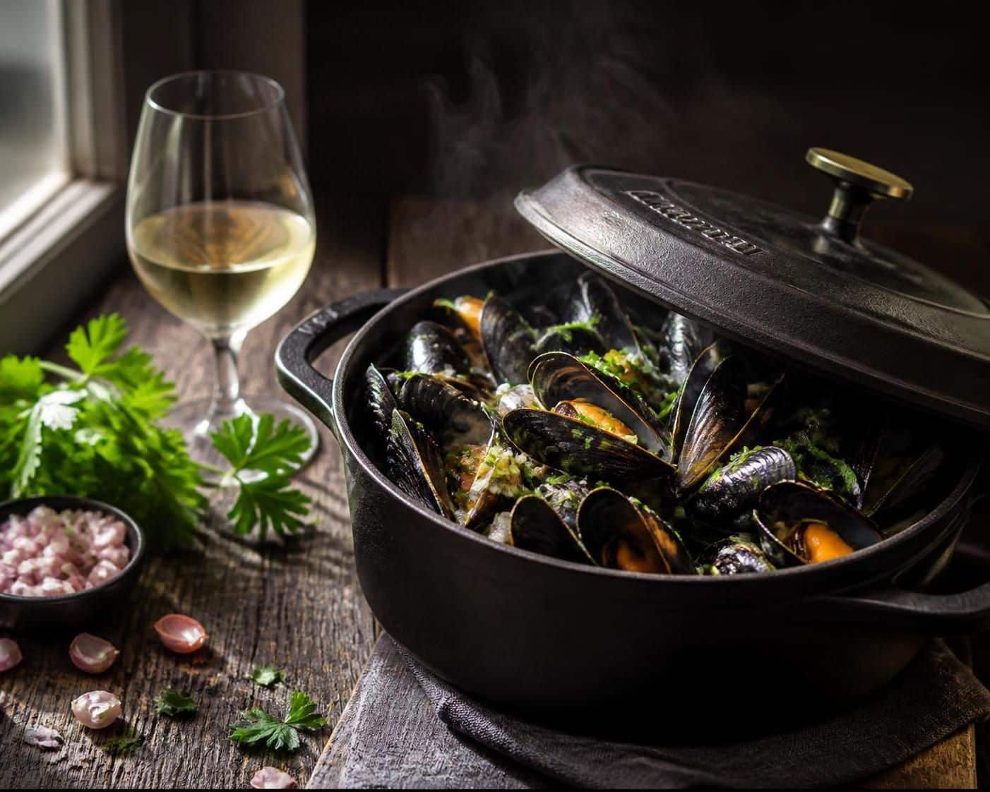 Plat de moules marinières servi avec des frites et un verre